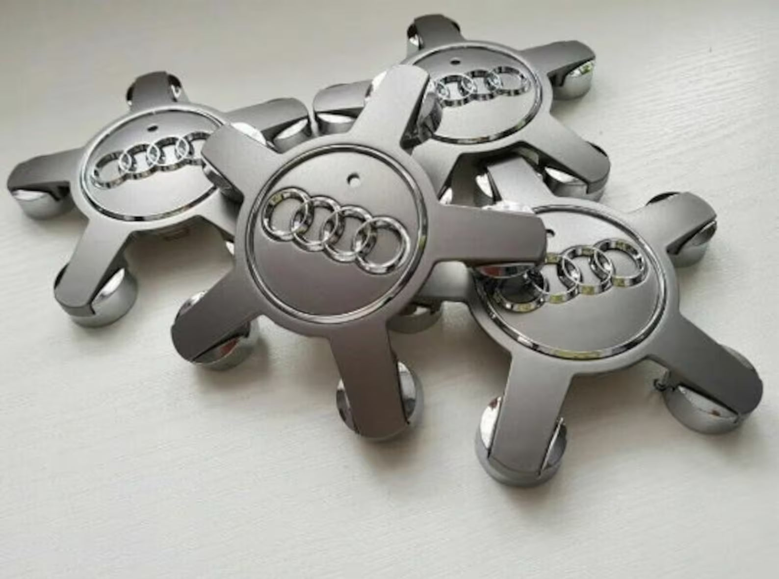 2x Centres de Roues Audi Étoiles 135mm Noir Chrome - vue de face - Becquet Voiture