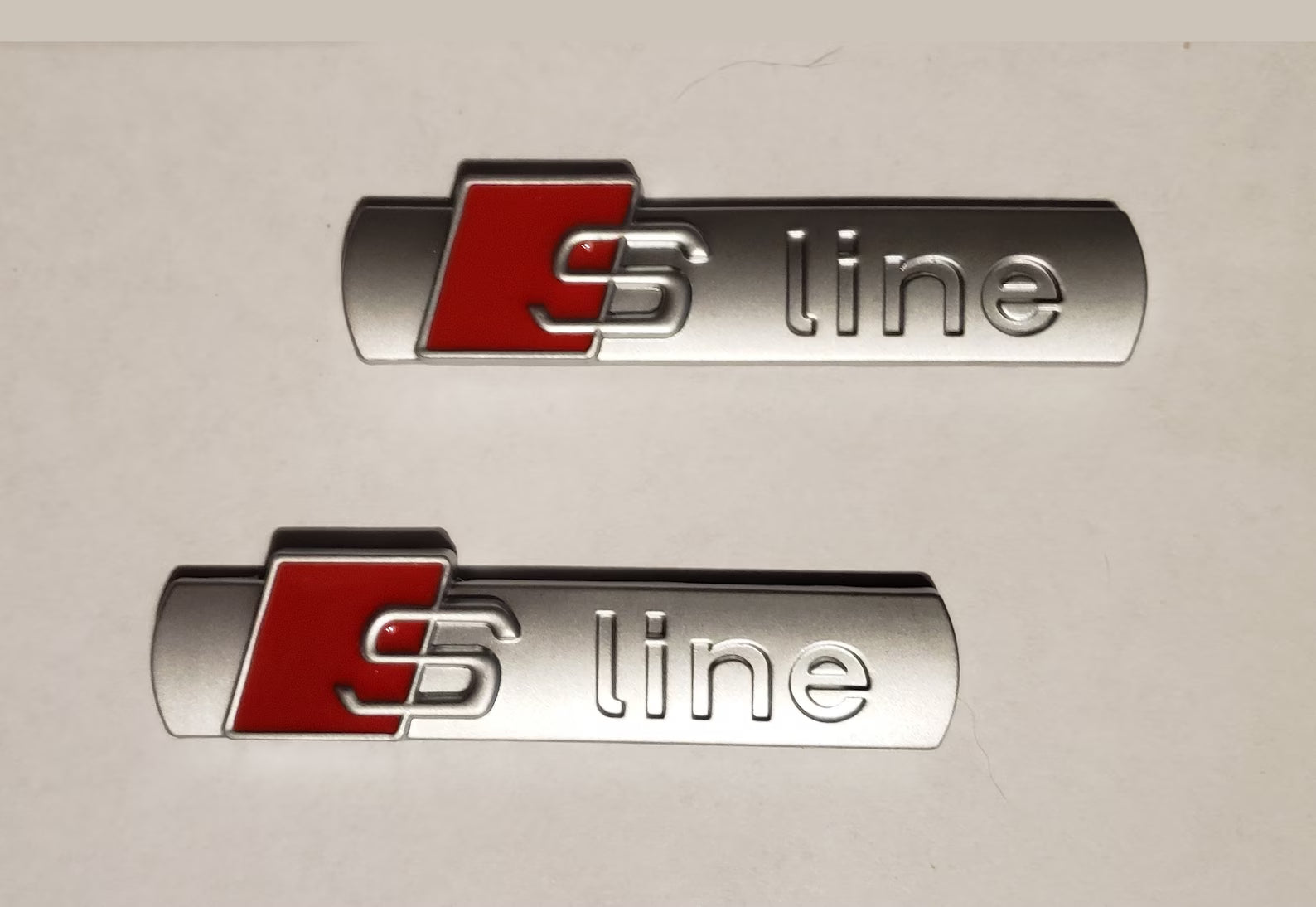 2x Emblèmes S-Line Origine Audi Gris Argent - vue de face - Becquet Voiture