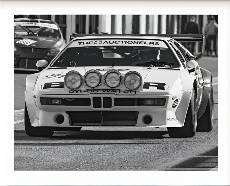 https://cdn.shopify.com/s/files/1/0565/4957/2747/files/Affiche-noir-et-blanc-vintage-voiture-ancienne-BMW-M1-Procar.png?v=1761584237