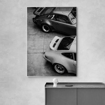 https://cdn.shopify.com/s/files/1/0565/4957/2747/files/Affiche-noir-et-blanc-vintage-voiture-ancienne-Porsche-911-et-356-3.webp?v=1761583116