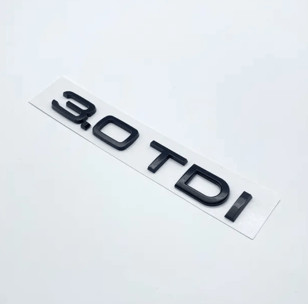 https://cdn.shopify.com/s/files/1/0565/4957/2747/files/Badge-de-coffre-lettres-noires-motorisation-AUDI-3_0-TDI.png?v=1761577490