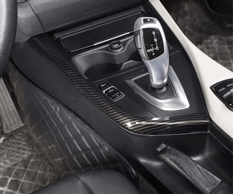 https://cdn.shopify.com/s/files/1/0565/4957/2747/products/Insert-interieur-carbone-entourage-levier-de-vitesse-pour-BMW-Serie-1-F20-2011-2019.png?v=1761576972
