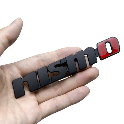 Logo Nismo Badge Nissan Noir Chrome Avant Arrière - vue de trois-quarts - Becquet Voiture